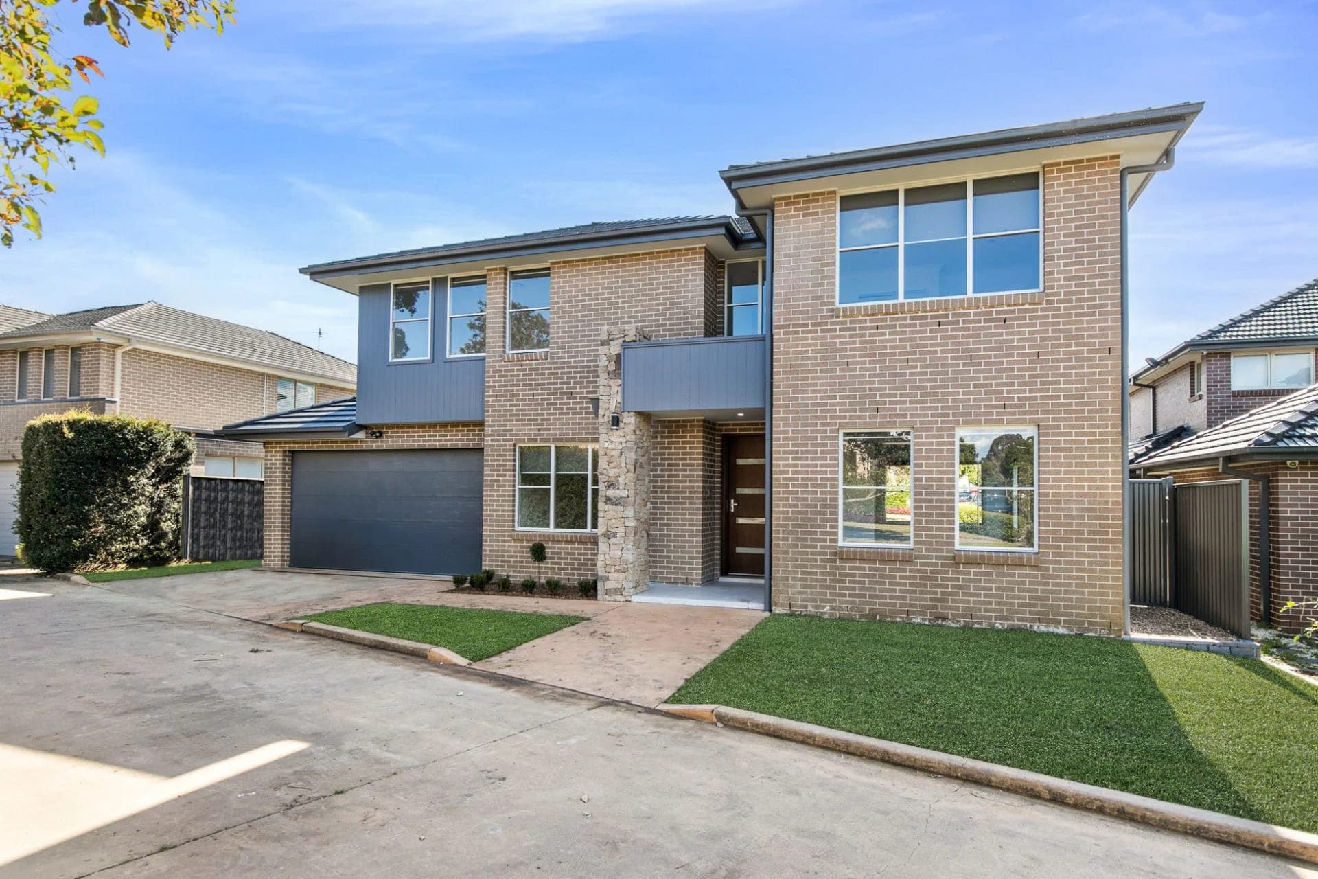Two-storey brick home with timber-clad upper level and double garage